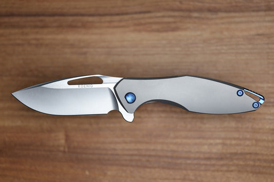 KOENIG KNIVES ARIUS – SMOOTH TITANIUM HANDLE – BLUE HARDWARE – BURNISHED W/ POLISHED FLATS M390 BLADE (PREOWNED)