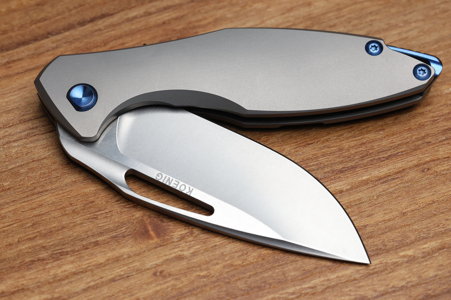 KOENIG KNIVES ARIUS – SMOOTH TITANIUM HANDLE – BLUE HARDWARE – BURNISHED W/ POLISHED FLATS M390 BLADE (PREOWNED)