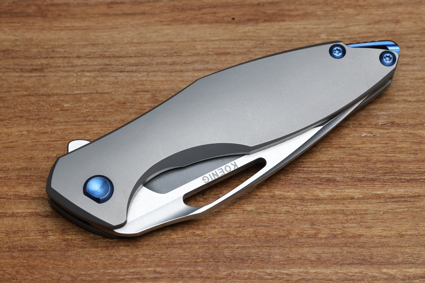 KOENIG KNIVES ARIUS – SMOOTH TITANIUM HANDLE – BLUE HARDWARE – BURNISHED W/ POLISHED FLATS M390 BLADE (PREOWNED)